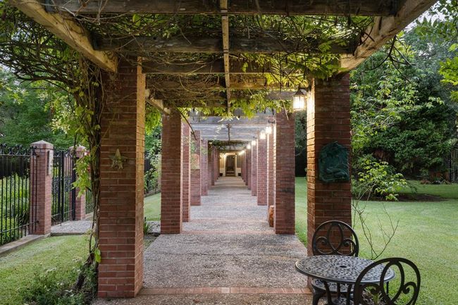 [The Walk of Reason and Logic] is 144 feet long & 9 feet wide; parallel brick colonnades, 14 columns per side, support an open lattice roof of cedar; columns are lighted; columns & roof are festooned with Madame Alfred Carrier climbing rose and wisteria. | Image 42