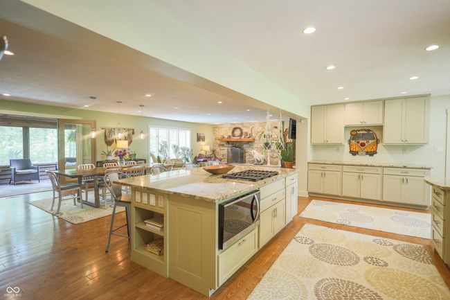 kitchen with recessed lighting, light stone countertops, light wood-style flooring, open floor plan, and decorative light fixtures | Image 21