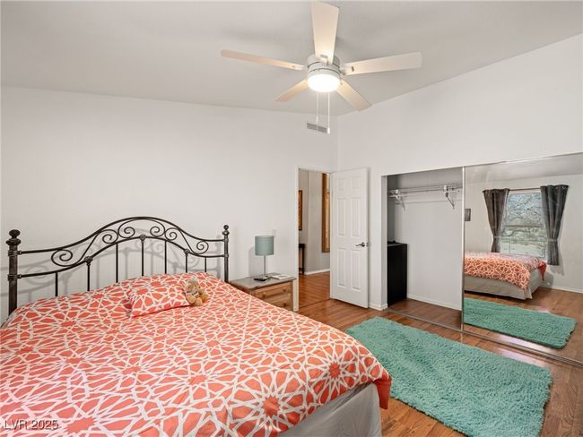 Bedroom with a ceiling fan, visible vents, wood finished floors, and a closet | Image 38