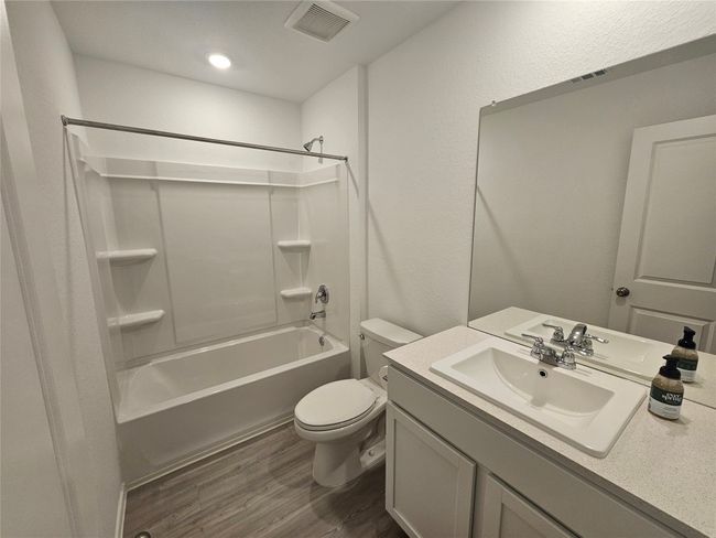 Full bath with vanity, shower / bathtub combination, toilet, visible vents, and wood finished floors | Image 27