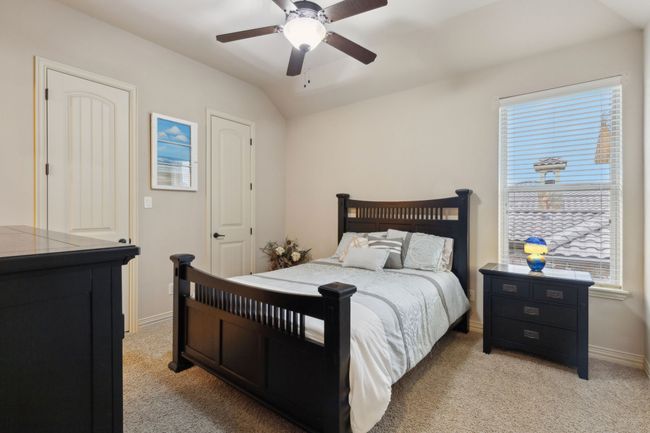 Bedroom featuring ceiling fan, lofted ceiling, baseboards, and light carpet | Image 20