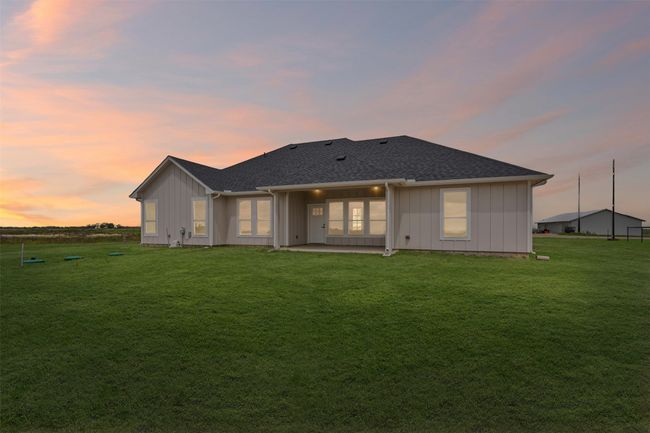 Back of property featuring a lawn, board and batten siding, a patio area, and roof with shingles | Image 38