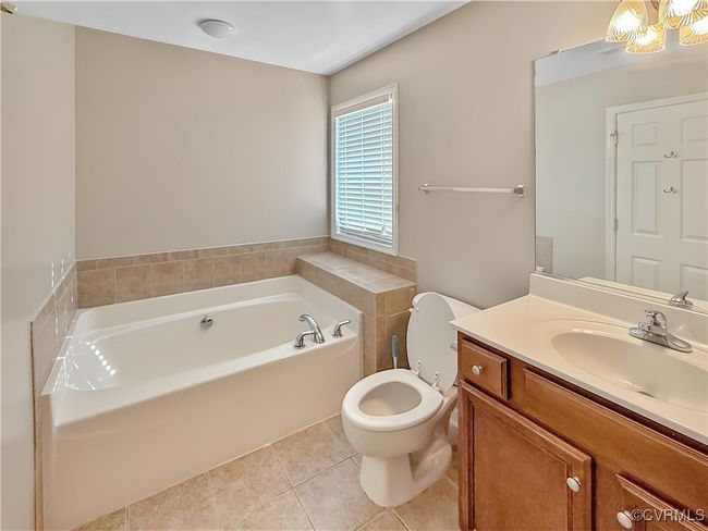 Bathroom with tile patterned flooring, a garden tub, and vanity | Image 16