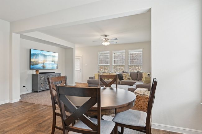 Dining space featuring dark wood-type flooring, a ceiling fan, and baseboards | Image 8