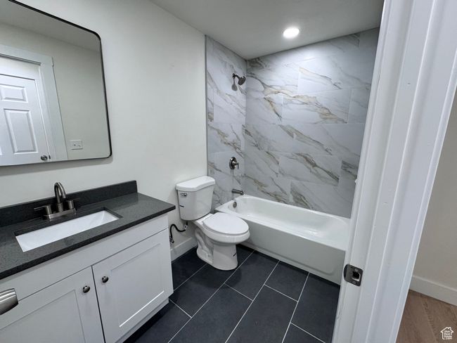 Bathroom featuring baseboards, toilet, recessed lighting, bathing tub / shower combination, and vanity | Image 28