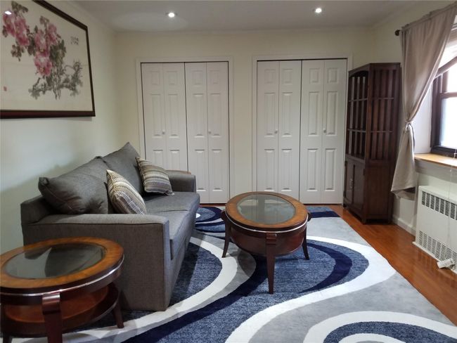 Living area with wood finished floors, radiator, recessed lighting, and crown molding | Image 4
