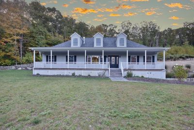 Farmhouse inspired home with a lawn and covered porch | Image 1