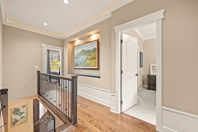 Hall featuring an upstairs landing, light wood finished floors, crown molding, and recessed lighting | Image 15