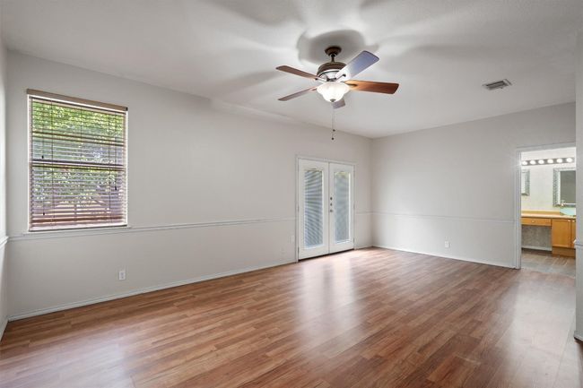 Primary bedroom with ceiling fan, french door to patio, and full bath en-suite | Image 20