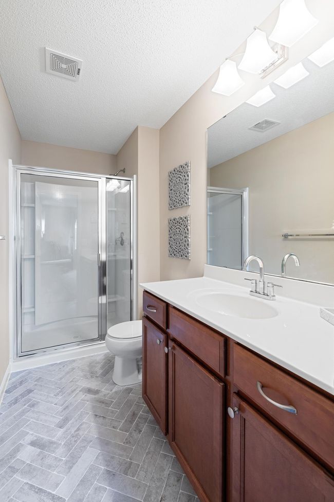 3/4 primary bathroom ensuite with new herringbone tile floors. | Image 15