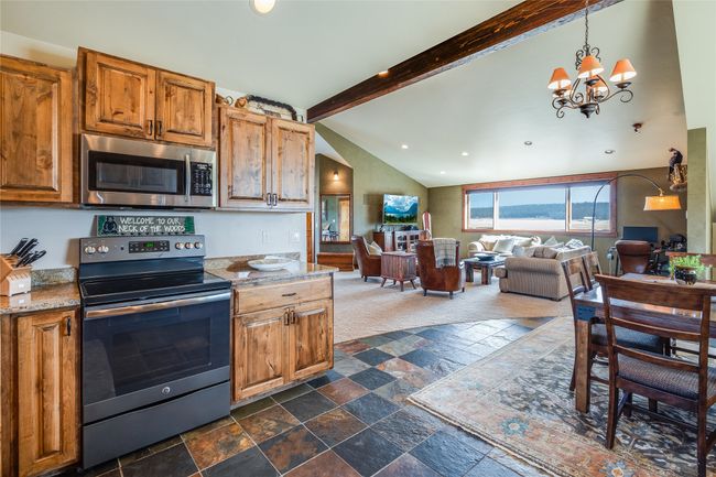 Caretaker Quarters / Guest House. Kitchen with appliances with stainless steel finishes, open floor plan, vaulted ceiling with beams, and stone tile floors | Image 69