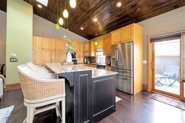 Kitchen featuring appliances with stainless steel finishes, a healthy amount of sunlight, wooden ceiling, light brown cabinetry, and vaulted ceiling | Image 9