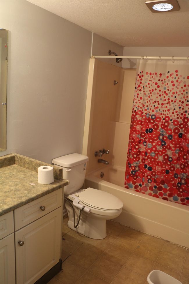 Full bath with vanity, shower / bathtub combination with curtain, and a textured ceiling | Image 18
