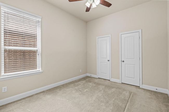 Unfurnished bedroom with carpet flooring, baseboards, and ceiling fan | Image 7