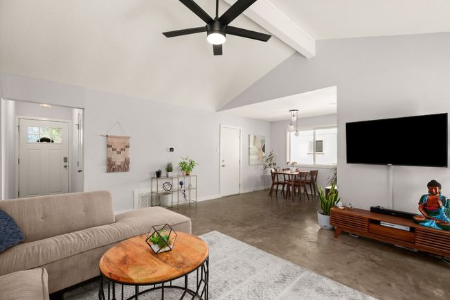 Living area featuring concrete flooring, a ceiling fan, and baseboards | Image 6