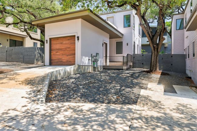 View of front of house featuring a gate, a garage, concrete driveway, and stucco siding | Image 22