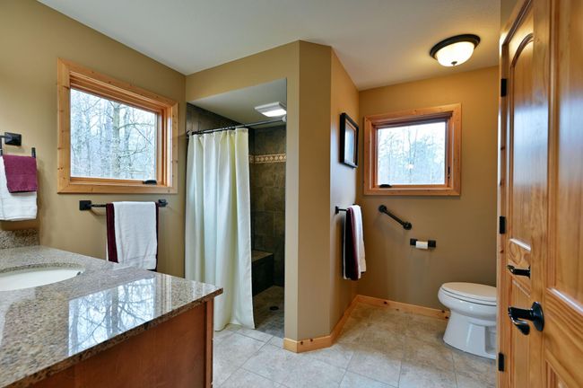 The bathroom has a curbless tile shower. | Image 40