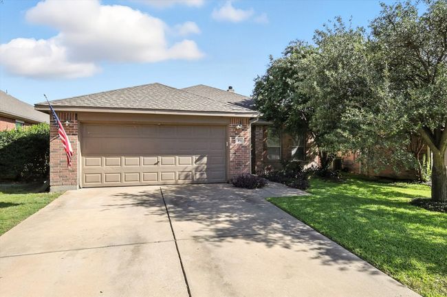 Ranch-style home featuring brick siding, a shingled roof, a front lawn, and a garage | Image 18
