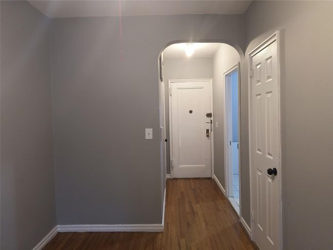 Corridor with arched walkways, dark wood-type flooring, and baseboards | Image 10
