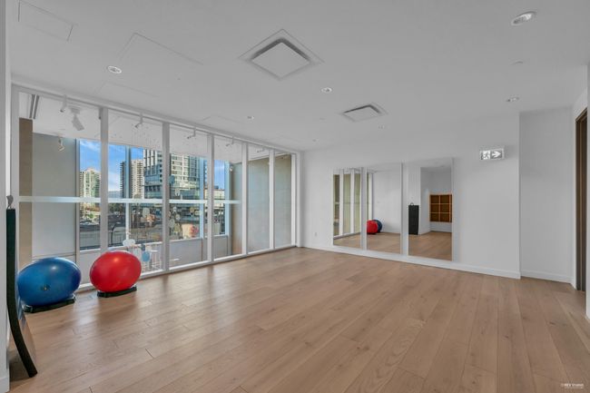 Exercise room with a view of city, floor to ceiling windows, light wood-style flooring, and baseboards | Image 22