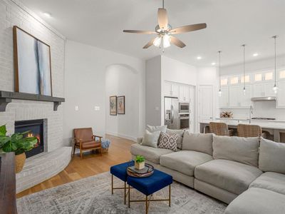 Living room with light hardwood / wood-style flooring, ceiling fan, and a fireplace | Image 3