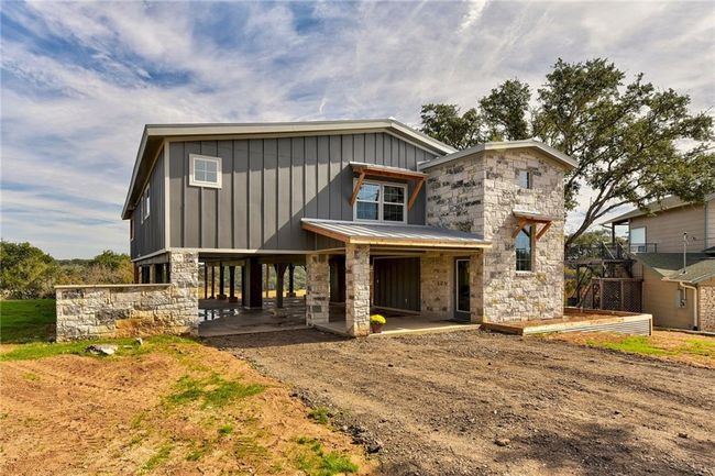 View of front facade featuring board and batten siding, stone siding, and a patio area | Image 5