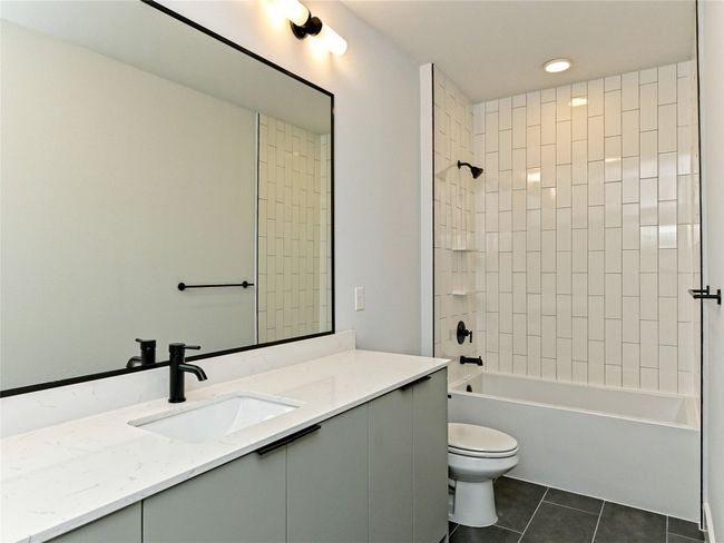Full bath featuring tile patterned flooring, vanity, toilet, and shower / washtub combination | Image 11