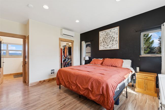 Bedroom featuring baseboards, a wall mounted air conditioner, recessed lighting, a walk in closet, and light wood finished floors | Image 31
