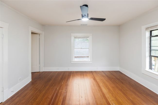 Unfurnished room with wood-type flooring, a ceiling fan, crown molding, and baseboards | Image 12