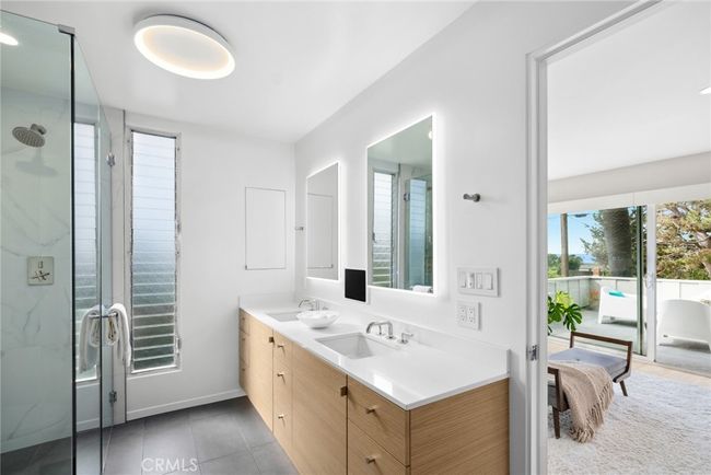 Displaying a brand-new renovation, the primary bath shines with an oversized shower, Schluter heated flooring, double vanity with custom riff-cut oak cabinetry, and a walk in closet. | Image 31