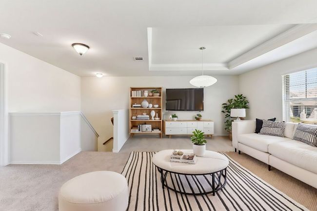 Living room featuring baseboards, a raised ceiling, visible vents, and light carpet | Image 13