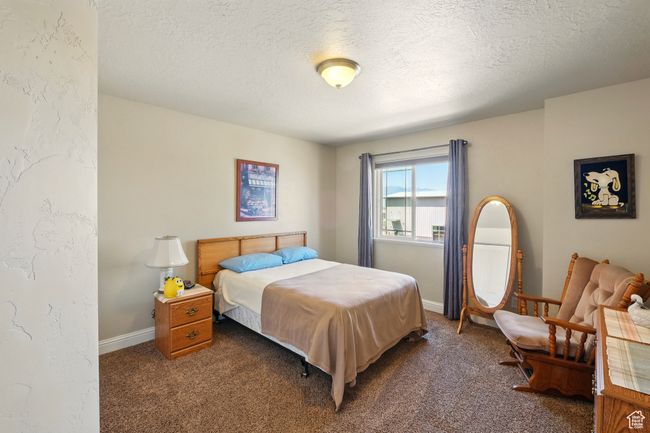 Carpeted bedroom with a textured ceiling and baseboards | Image 18