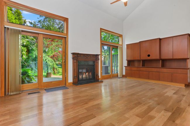 Unfurnished living room with high vaulted ceiling, a ceiling fan, plenty of natural light, a high end fireplace, and light wood-style floors | Image 17