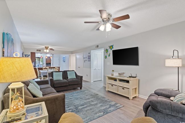 Living room featuring baseboards, a ceiling fan, light wood finished floors, and visible vents | Image 17