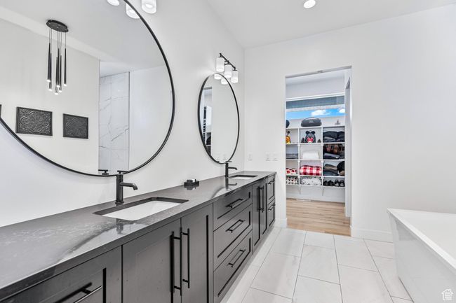 Full bath with a walk in closet, double vanity, a sink, and a freestanding tub | Image 23