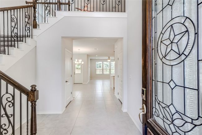 Foyer entrance featuring a chandelier, baseboards, stairway, and light tile patterned floors | Image 5