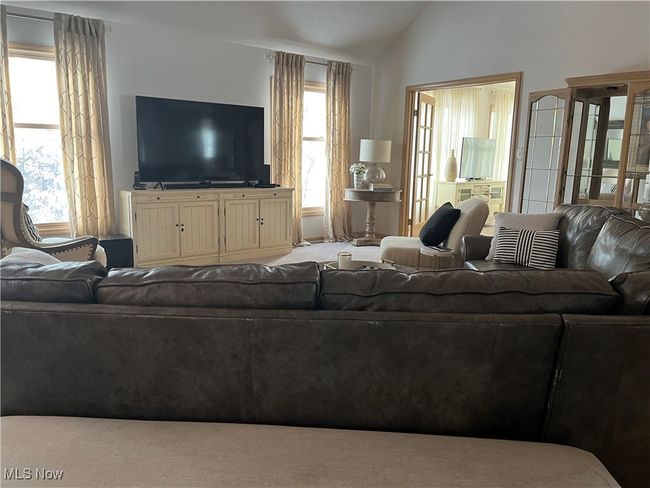The Great Room has a lofted ceiling, a healthy amount of sunlight, and carpet flooring | Image 11