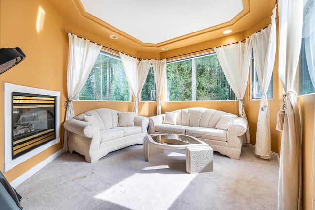 Living room featuring carpet floors, a glass covered fireplace, baseboards, and recessed lighting | Image 24
