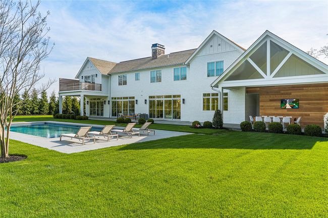Rear view of property featuring a balcony, a patio, board and batten siding, and an outdoor pool | Image 43