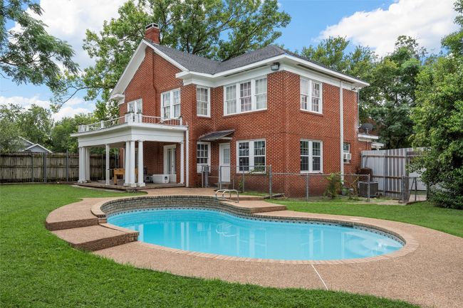 Back of property featuring a balcony, brick siding, a chimney, a fenced backyard, and a patio area | Image 32