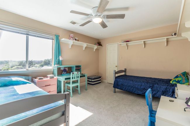 Bedroom featuring light colored carpet, ceiling fan, and baseboards | Image 22
