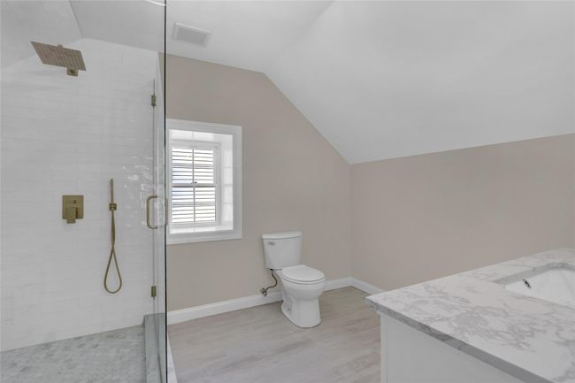 Full bath with a stall shower, visible vents, lofted ceiling, toilet, and wood finished floors | Image 20