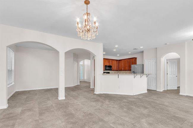 Unfurnished living room featuring arched walkways, recessed lighting, and a chandelier | Image 4