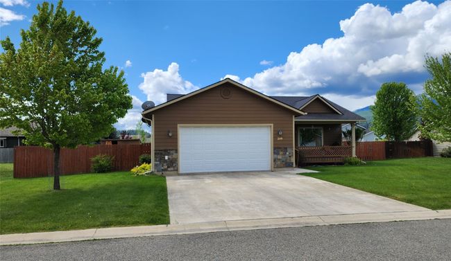 Ranch-style house featuring an attached garage, concrete driveway, stone siding, and a porch | Image 48