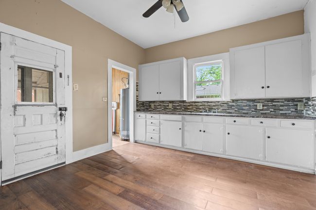 Kitchen with hardwood / wood-style floors, decorative backsplash, ceiling fan, and white cabinets | Image 10