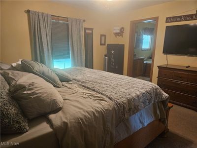 Bedroom with ensuite bathroom and carpet flooring | Image 2