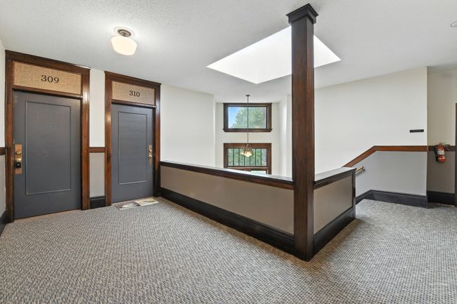 Hallway landing with large windows and warm natural light offering access to 309. | Image 6