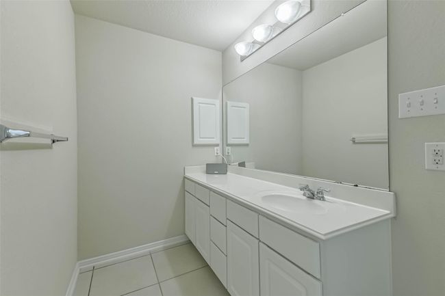 The Primary bathroom features a gleaming vanity with a single sink and ample counter space--complemented by neutral wall tones and a towel rack for convenience. | Image 22