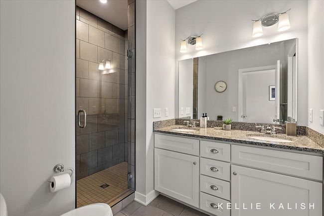 Spa-like primary bathroom with walk-in shower, double sink set in quartz, and walk-in closet. | Image 20