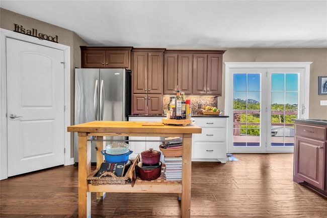 Kitchen featuring dark wood-type flooring, dark countertops, and freestanding refrigerator | Image 11